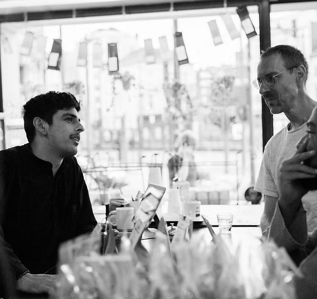 Black and white photograph of the artist at a café